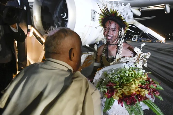 Pope Francis arrives in Papua New Guinea after a six-hour flight from Jakarta, welcomed by traditional Mekeo tribe members and civil leaders in Port Moresby